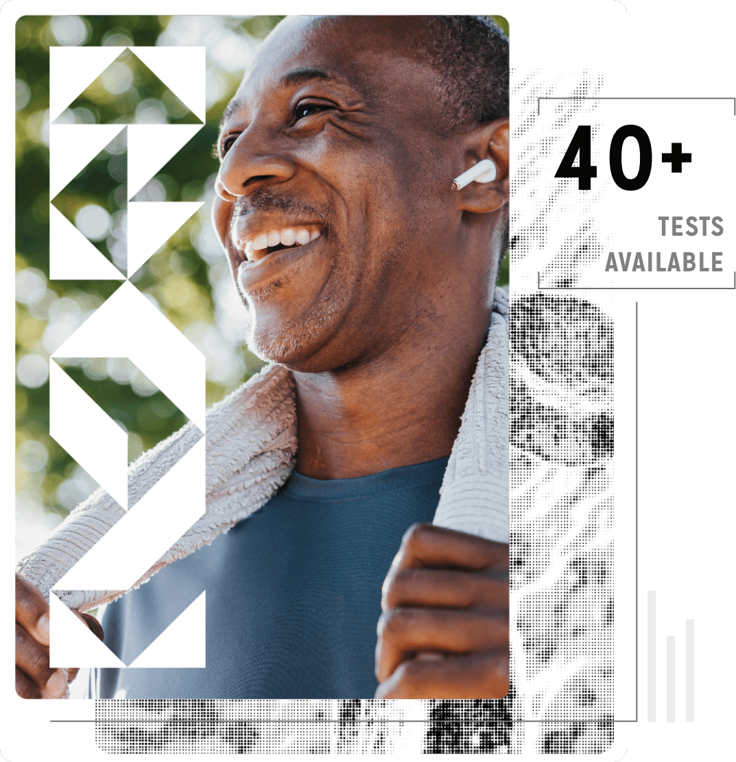 A happy young Black man wearing earbuds and carrying a towel, as if preparing for a workout.